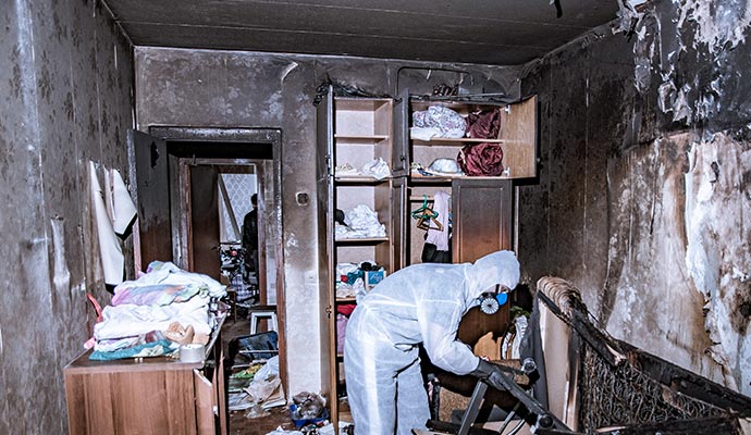 Worker in safety gear providing smoke damage restoration service