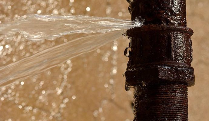 Close up view of water bursting out of a broken pipe